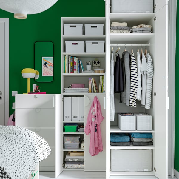 Well-organized wardrobe with clothes hanging, books, and storage boxes.