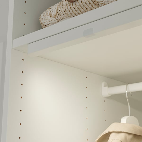 Closet with adjustable shelves, basket on top, jacket on middle rod.