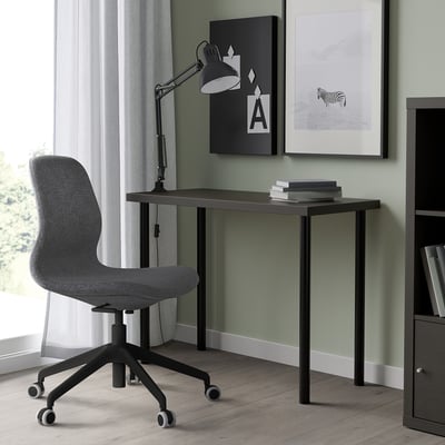 Modern home office setup with LINNMON desk, grey chair, adjustable lamp, and wall art. Desk shallow, fits small spaces.
