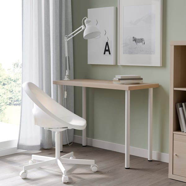 White LINNMON desk with light wood top, green wall, lamp, chair, and two art prints - minimalist workspace.