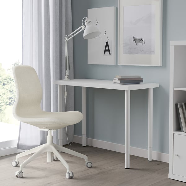 White LINNMON desk & chair, minimalist, adjustable, with a lamp & books.