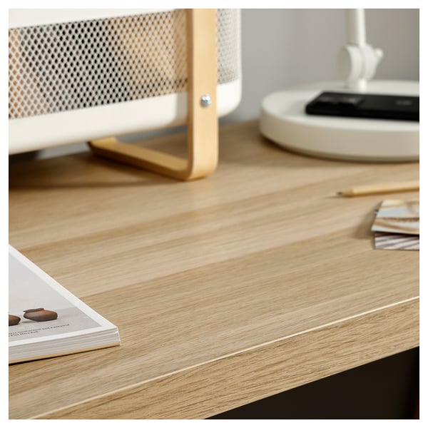Wooden desk with golden accents, books, and a lamp. Modern design, ideal for small spaces.