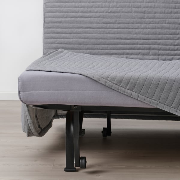 Convertible sofa-bed with steady mattress, showing frame and wheels for easy movement.