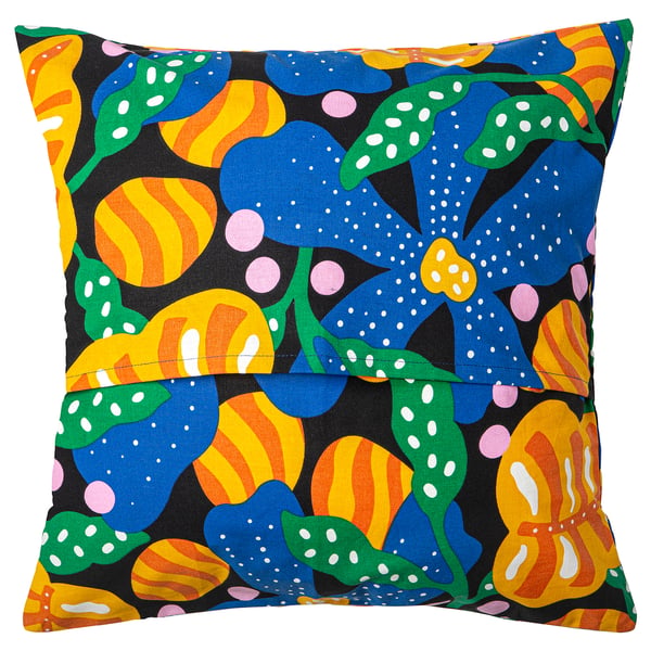The MÄVINN pillow cover vibrant, abstract flowers on black fabric with embroidered edges, creating a striking and tactile design.
