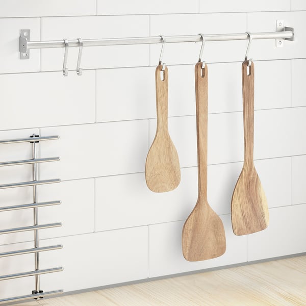 Three MAJFISK wooden spoons hang on metal rod by white wall, practical and non-stick.