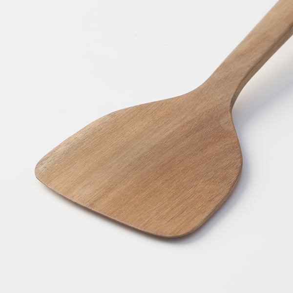 Wooden spatula with smooth, light brown finish against a white background, crafted from solid acacia wood.