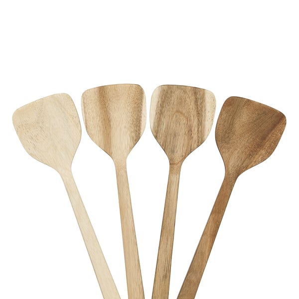 Four wooden spatulas, varying shades from light to dark, lean against each other; handles have holes for hanging.