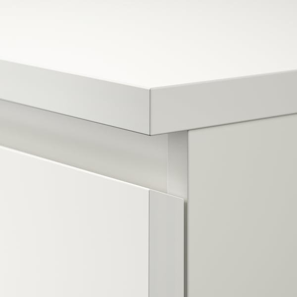 Close-up of white MALM dresser corner. Clean, precise joints. Smooth, even finish.