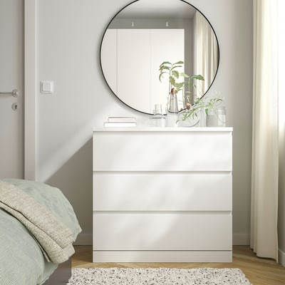 White MALM chest with mirror, smooth drawers, wall-anchored.