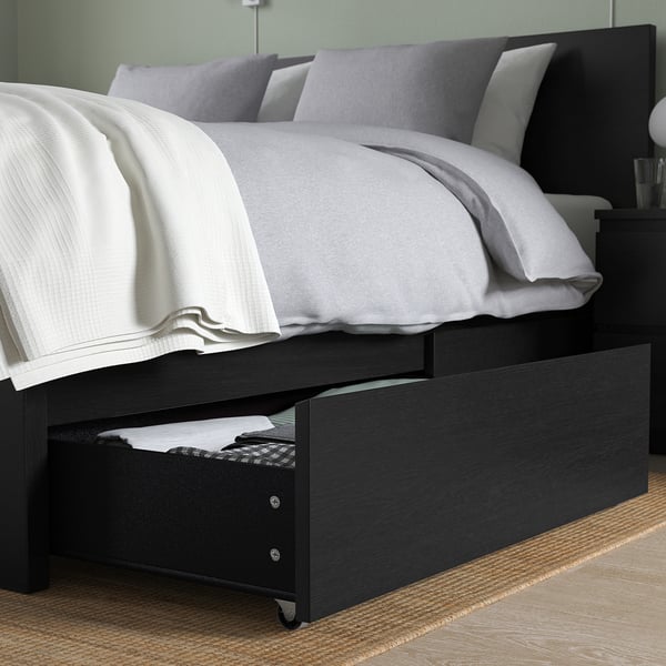 Modern bed with wooden frame, high headboard, four drawers & grey/white bedding.