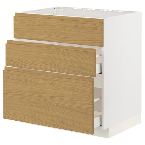 A white METOD kitchen cabinet with three wood-grain drawers. The cabinet has a minimalist design with integrated handles.