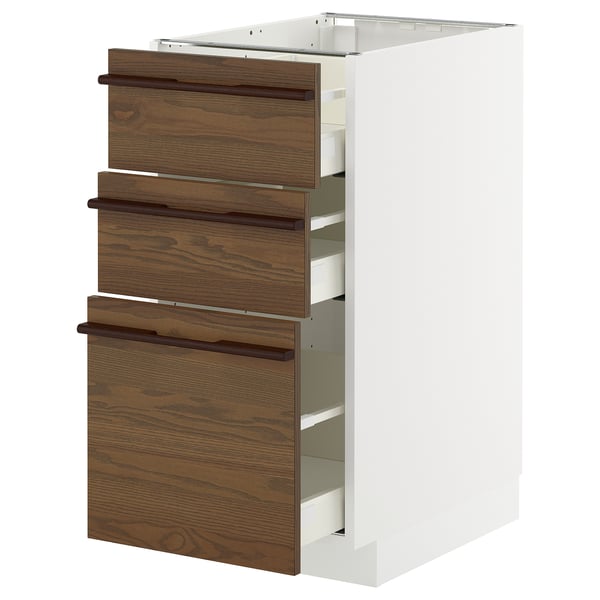A white METOD kitchen cabinet with dark brown ash veneer drawers and wooden handles.