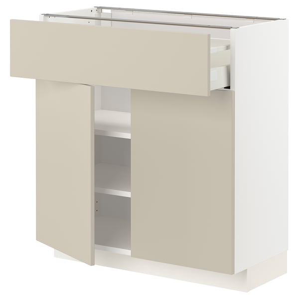 White and beige kitchen cabinet from IKEAs METOD series with adjustable shelves and smooth drawer fronts.