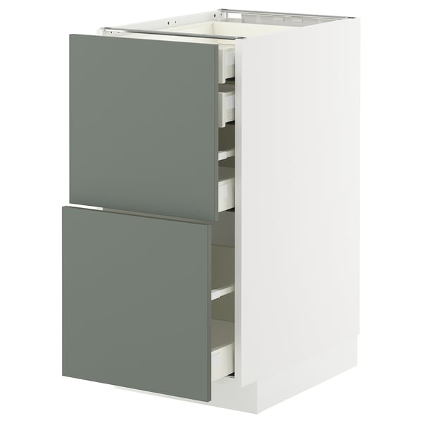 Modern kitchen cabinet with grey-green drawers and white frame.