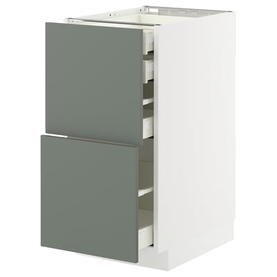 Modern kitchen cabinet with grey-green drawers and white frame.