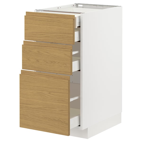 METOD kitchen unit with oak drawers and white frame.