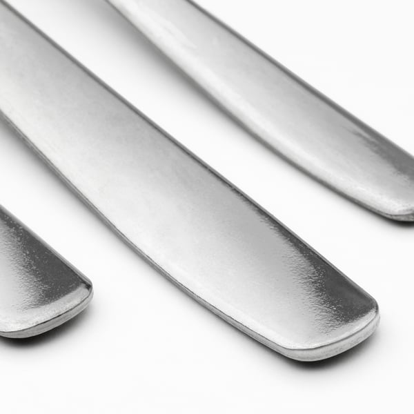 Three polished metal utensils, likely stainless steel, arranged neatly in a row, showcasing their smooth, reflective surfaces and clean design.