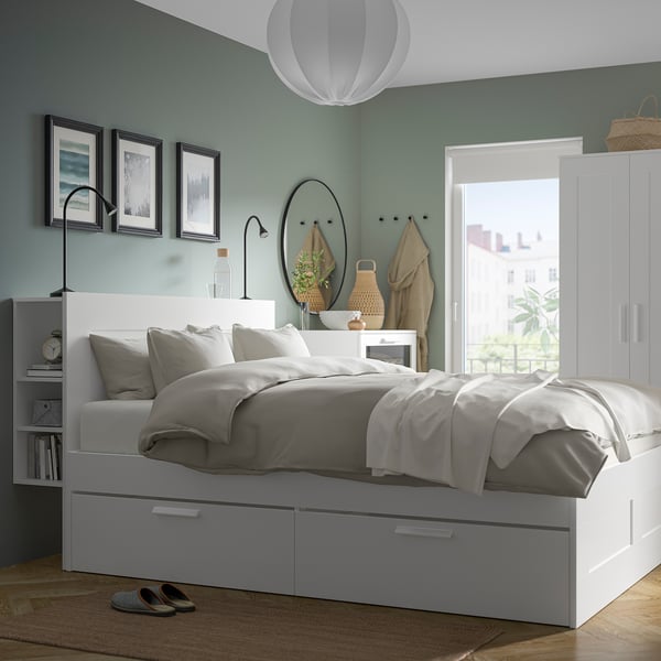 Modern bedroom with blue walls, NÄVLINGE lamp by bed, minimalist decor.