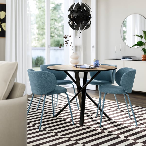 Modern dining set: round table, blue chairs. Table fits small spaces; chairs have metal legs.