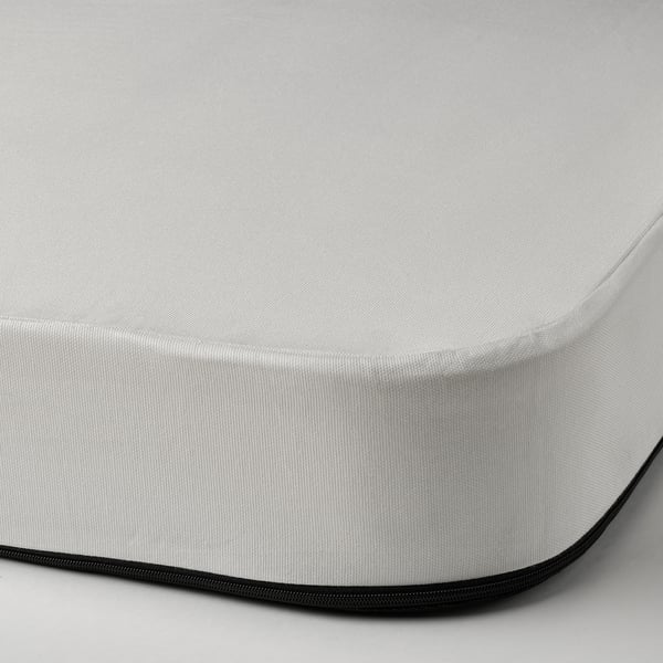 Close-up of a white, high-quality mattress with a zippered, black edge, showcasing its soft, textured surface.