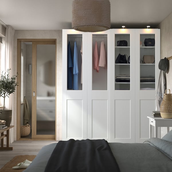 Modern white wardrobe with glass panels and purses. Tall, sleek with textured lampshade.