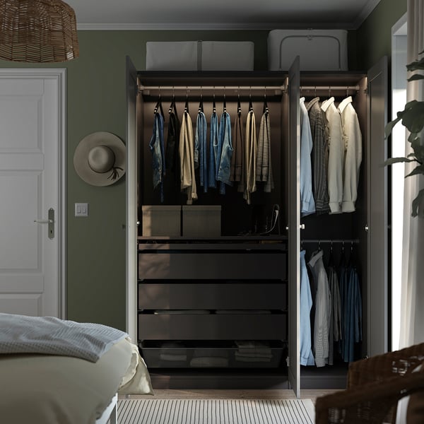 Open wardrobe displaying hangers with clothes, shelves, and storage bins. Integrated lighting highlights the items.