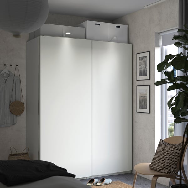 Modern bedroom with white PAX wardrobe, sliding doors, and teachable decor.
