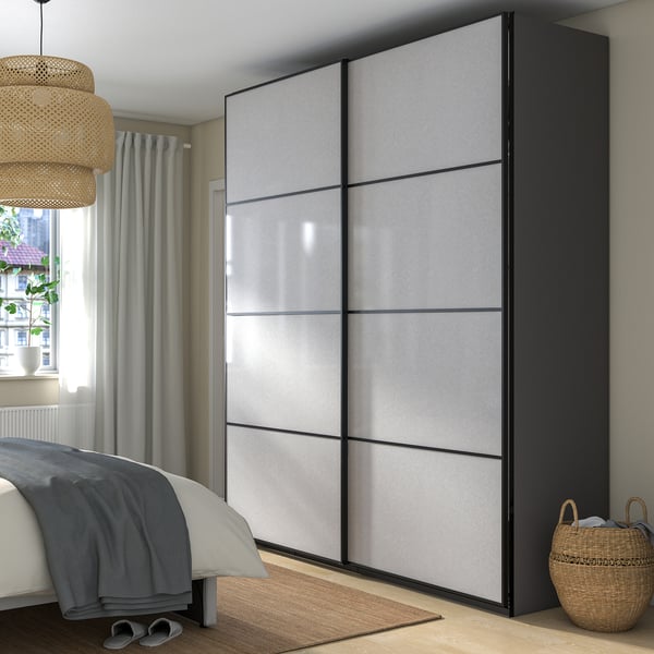 Modern bedroom with tall grey PAX wardrobe, minimalist decor.