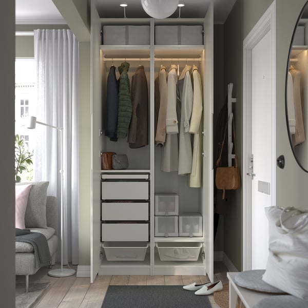A well-organized open wardrobe displays coats, jackets, and drawers. Interior lights illuminate the clothes and storage solutions.