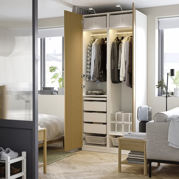 A modern closet with hangers, shelves, and drawers, featuring built-in lighting.