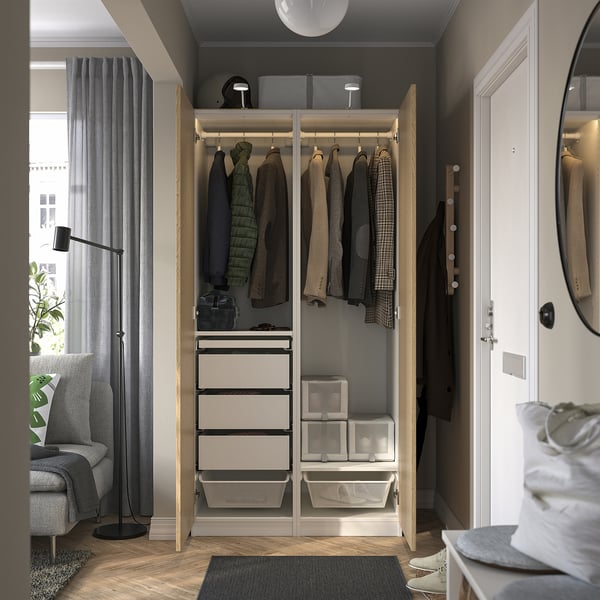 Modern open wardrobe displaying clothes, drawers, and storage bins. Integrated lighting illuminates the interior.