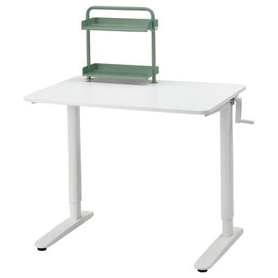A white RELATERA adjustable desk with a green shelf. The crank handle allows height adjustment for sitting or standing.