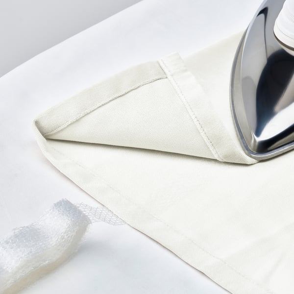 White iron curtain on rod, folded on white surface, with eyelets for sliding, and linen texture for privacy.