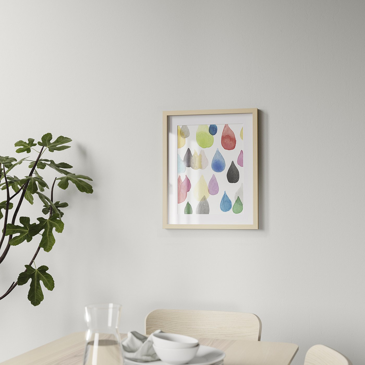Framed abstract art hangs on a dining room wall, above a wooden table with chairs.