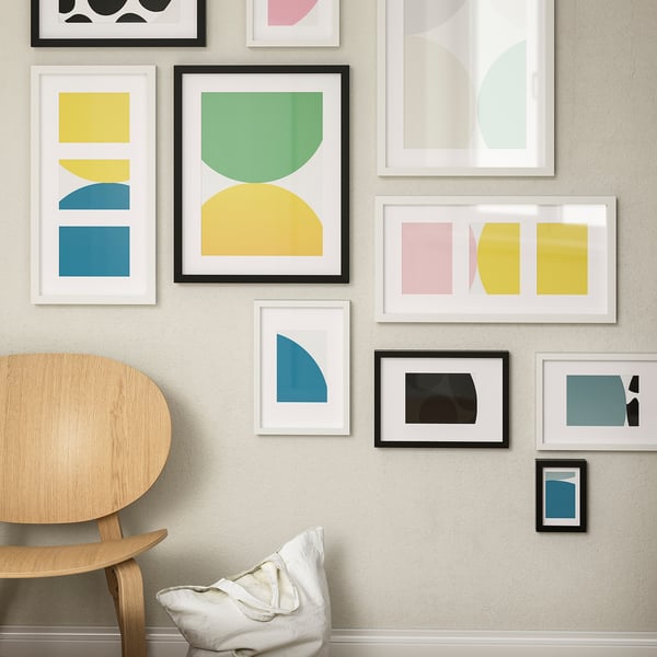 Colourful abstract art gallery wall with geometric designs, chair, and pillow. Or abstract art gallery wall with colours, chair, and pillow.