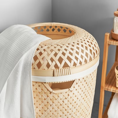 Woven bamboo laundry basket with white inner bag, natural colour, diamond pattern design, cylindrical shape.