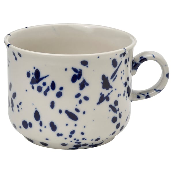 White ceramic mug with blue speckled design, handle on right side.