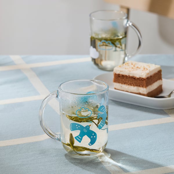 Blue bird mugs on blue tablecloth, perfect for tea/coffee.
