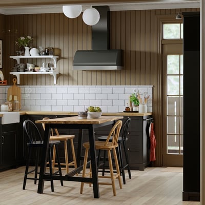 Modern kitchen with dark brown cabinets, black stools, white subway tiles, and wooden table; stylish & practical design.