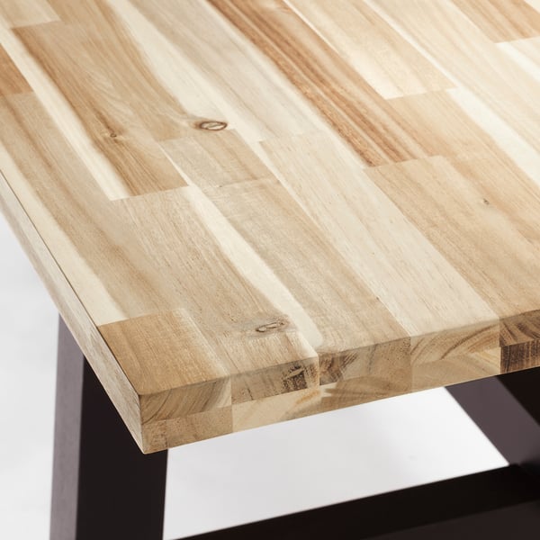 Close-up of high-quality wooden table with smooth, natural grain finish on top.