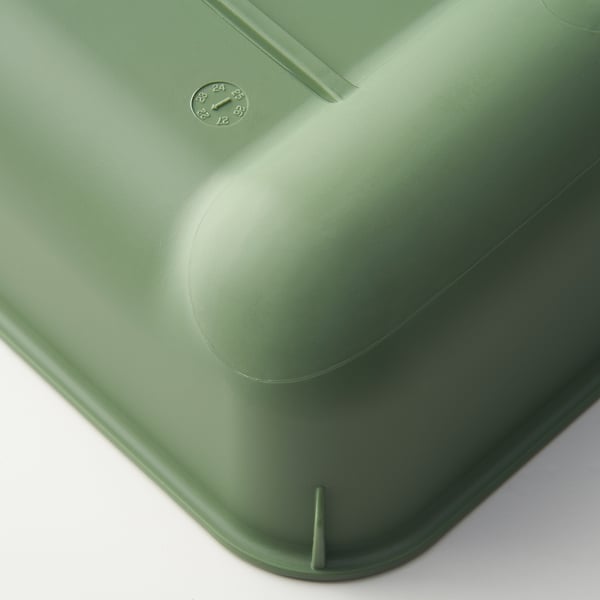 Green plastic strainer with round, smooth edge and small clock-shaped label, ideal for kitchen use.