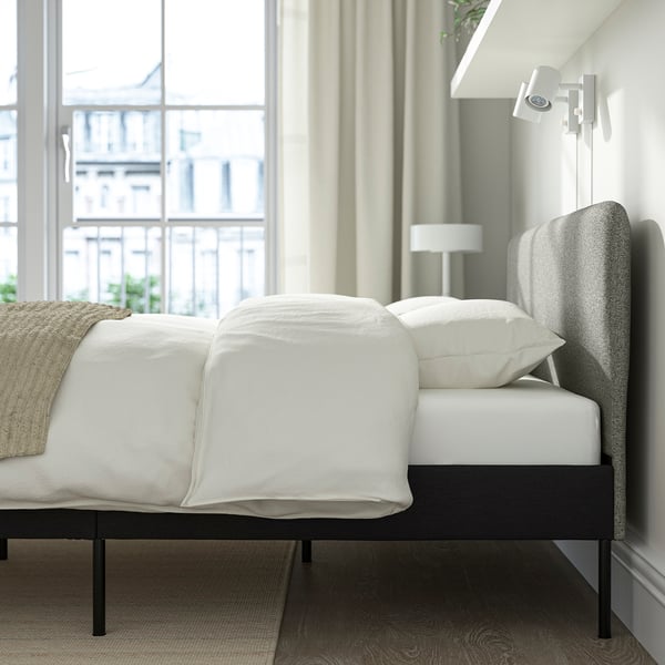 Modern bedroom with SLATTUM bed, white bedding, large window, small bedside lamp.