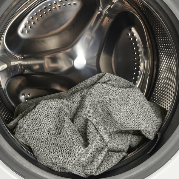 Washing machine interior showing drum and soiled clothes.