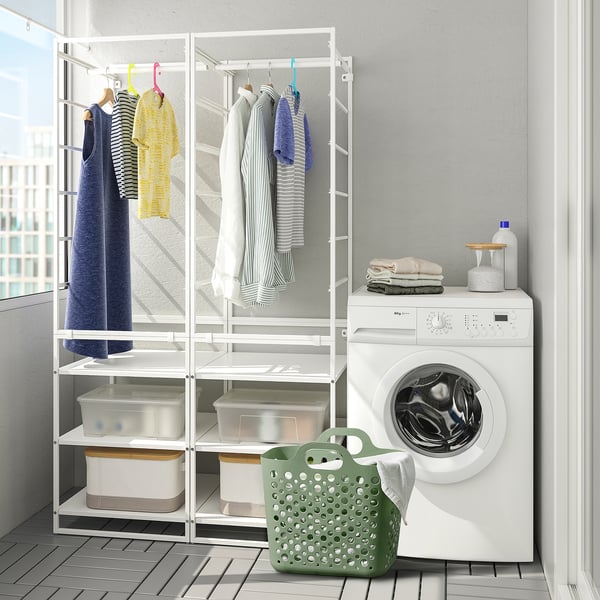 Modern laundry room with white washing machine, drying rack holding clothes, and green mesh laundry basket.