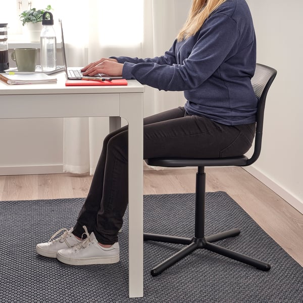 Person sitting at desk on adjustable swivel chair, typing on laptop. The chair has a textured seat and high back for comfort.