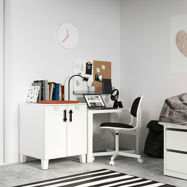 Minimalist white desk setup with adjustable chair, laptop, books, and clock on wall.