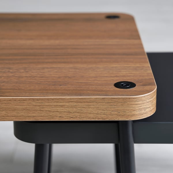 Wooden tabletop with smooth, honey-hued finish supported by black metal legs, highlighting modern design and sturdy construction.