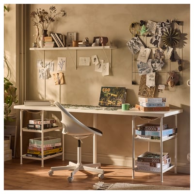 Modern white home office setup with SPÄND desk, shelves, and chair. Decorated with puzzles, books, and art.