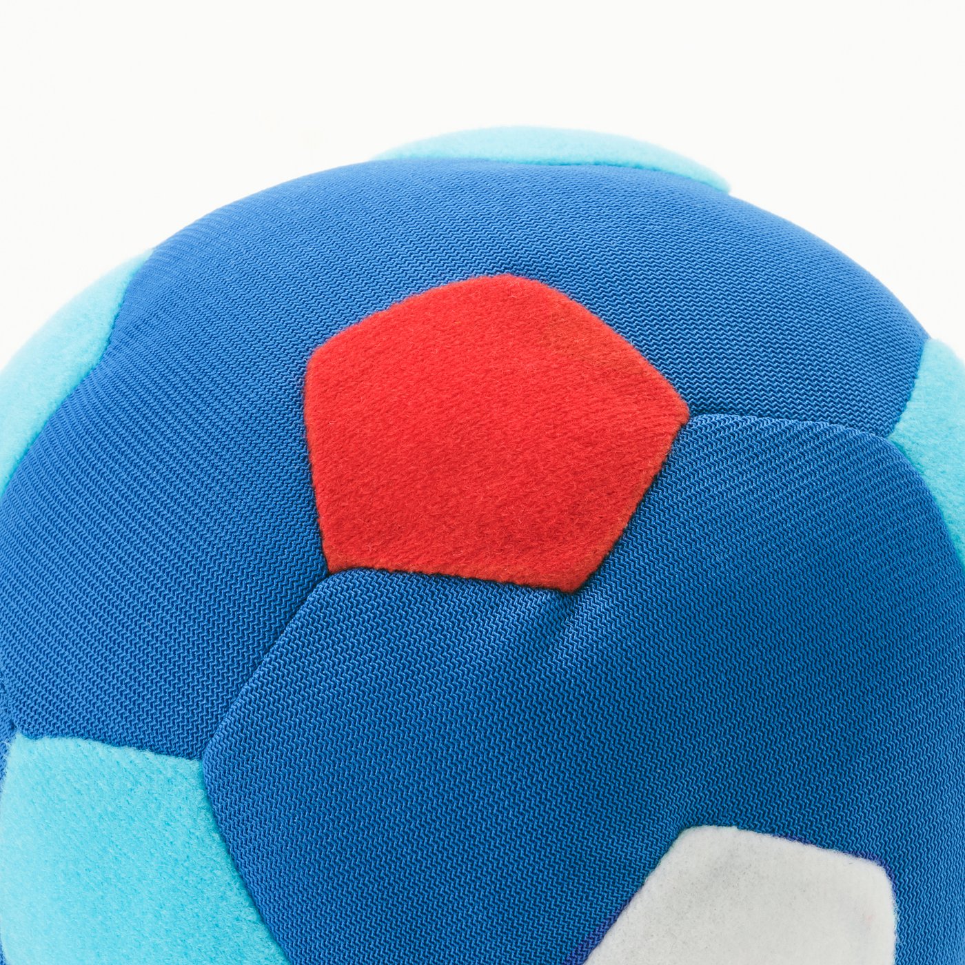 Close-up of brightly coloured, soft, textured football with red, blue, and cyan patches.