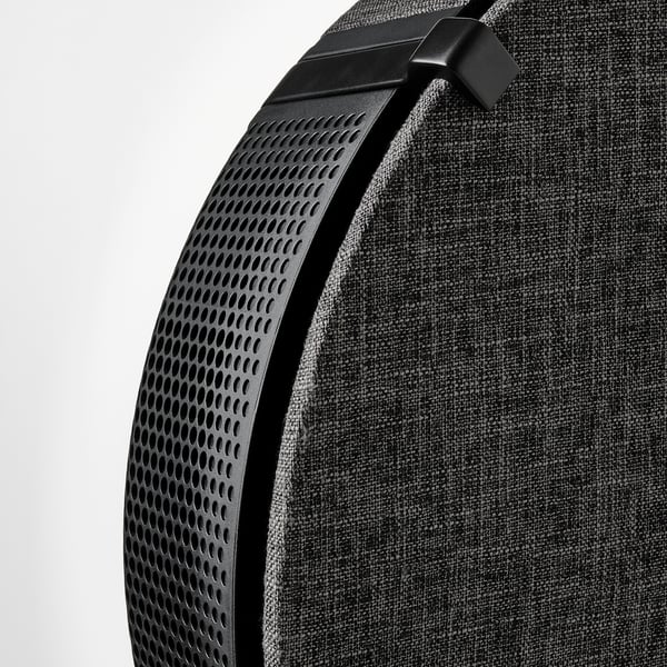 Modern air purifier with perforated design and fabric cover, sleek handle, advanced filtration system.